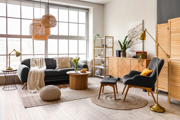 Interior of stylish living room with cozy sofa and coffee table near big window