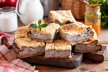 Delicious cottage cheese poppy-seed cake made of shortcrust pastry decorated with biscuits. Cheesecake with different beautiful layers.