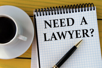 NEED A LAWYER? - words on a white sheet on a yellow wooden background with a pen and a cup of coffee