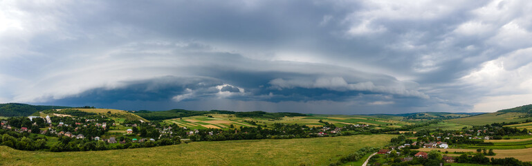 Fototapeta na wymiar Landscape of dark clouds forming on stormy sky during thunderstorm over rural area