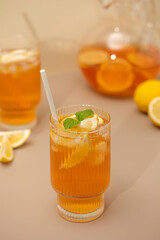 Iced tea with lemon and mint in a glass and in a jug. Summer drinks.