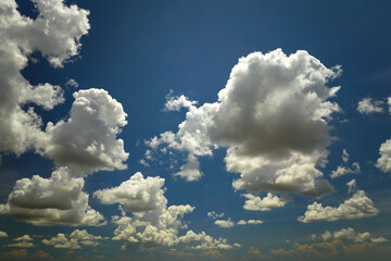 White puffy cumulus clouds on summer blue sky