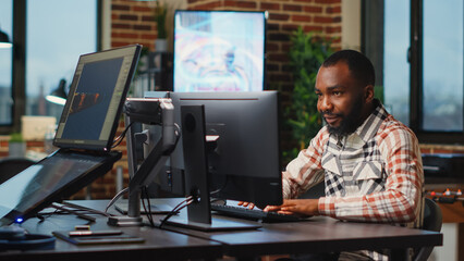 African american male artist working in studio office to create CGI production on software, digital skills. Creative agency designer using professional interface to develop infographics.