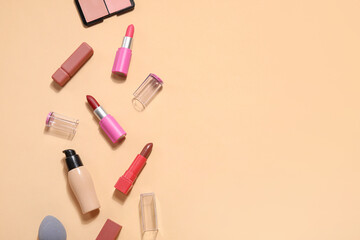 Decorative cosmetics with lipsticks on beige background