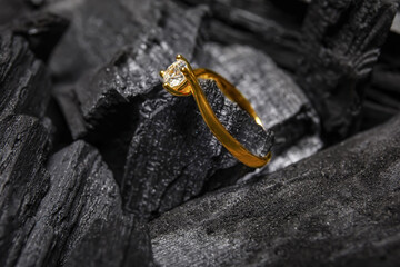 Golden ring on black charcoal, closeup