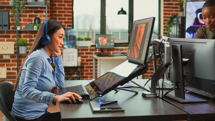 Creative agency artist working in manufacturing and production department, creating professional content in office. Asian woman developing 3D graphics components with engineering software.