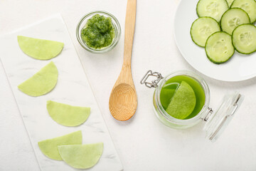 Cotton under-eye patches with cucumber slices on white background