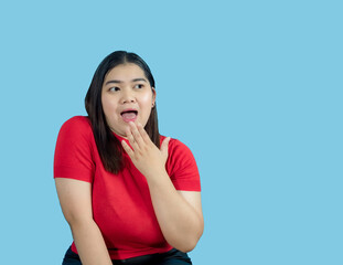 Portrait girl young woman asian chubby fat cute beautiful pretty one person wearing a red shirt is sitting smiling enjoy happily looking wow to copyspace imaginary on the blue background