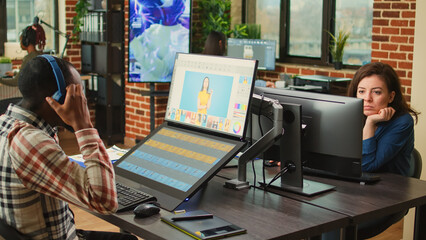 Young content creator retouching photos with color grading, using touchscreen monitor and stylus. Image editor with graphic tablet using editing software to retouch picture in agency studio.