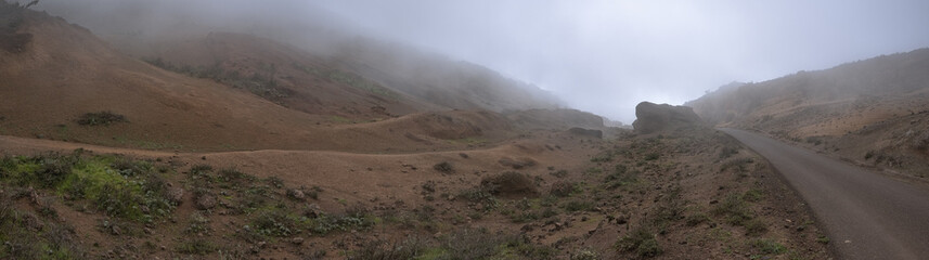 Huge panorama landscape of road in orange foggy mountains desert, resembling mars and dune, in tenerife, canarias, spain