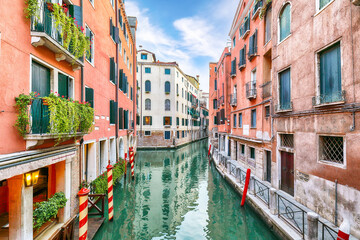 Fototapeta na wymiar Gorgeous cityscape of Venice with narrow canals, boats and gondolas and bridges with traditional buildings