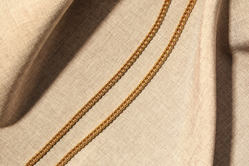 Beautiful chain necklace on beige fabric background