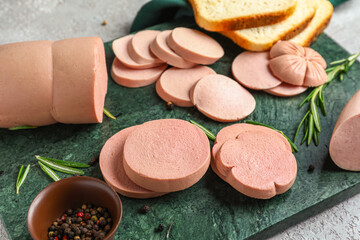 Obraz na płótnie Canvas Slate board with tasty sliced boiled sausage on table, closeup