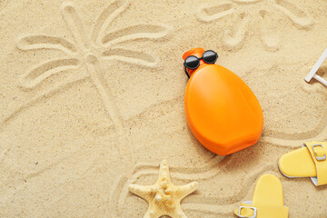 Fototapeta na wymiar Creative composition with sunscreen cream, sunglasses and flip flops on sand