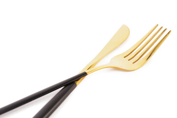Golden fork and knife with black handles on white background