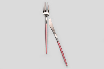 Stainless steel fork and knife on grey background