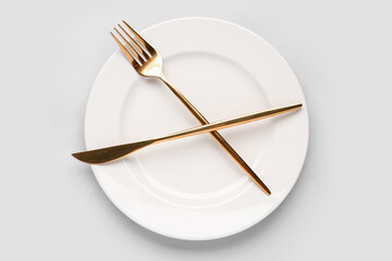 Table setting with clean plate on grey background