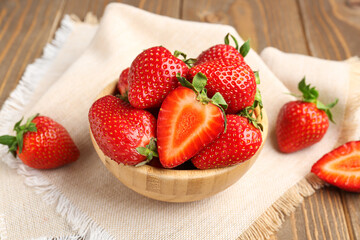 Bowl of fresh strawberries on wooden background