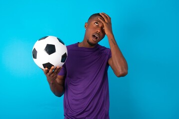 Horrible, stress, shock. Portrait emotional crazy Man wearing purple T-shirt holding a ball over...