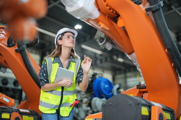 Mechanical engineers with robotic welder., Programming development technology work. Female industrial engineer working at automated AI robotic production factory..