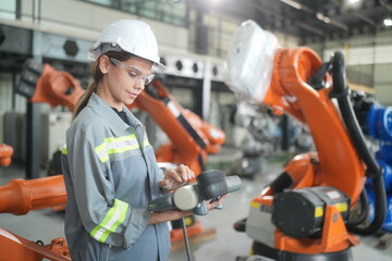Female industrial engineer working at automated AI robotic production factory.