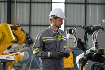 Robotics engineer working on maintenance of robotic arm in factory warehouse. Business technology.