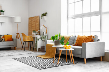 Interior of bright living room with cozy sofas, coffee table and comfortable workplace