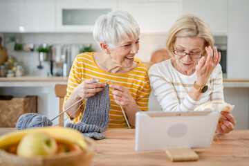 two women senior mature knitting and embroidery during leisure time