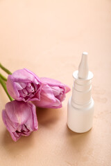 Obraz na płótnie Canvas Nasal drops with tulips on beige background, closeup. Seasonal allergy concept