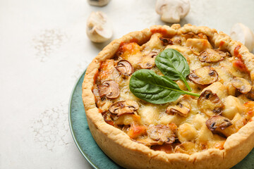 Mushroom pie with spinach leaves and cutlery on grunge table