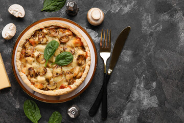 Mushroom pie with spinach leaves and champignons on dark grey grunge background