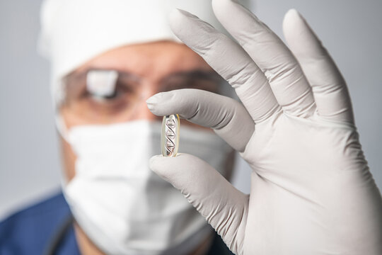 scientist man in goggles, gloves and mask holds DNA capsule, concept of scientific molecular biotechnology, study of human genetics, close-up - Powered by Adobe