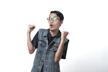 Asian man wearing sleeveless blue jean jacket gesturing happy to get gift or surprise. Isolated white background