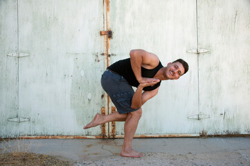 Photograph of a man practicing yoga in a grungy urban environment - 601226368
