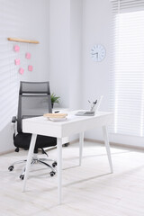Desk and comfortable chair in modern office. Interior design