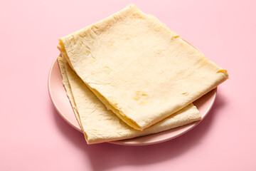 Plate with fresh thin lavash on pink background