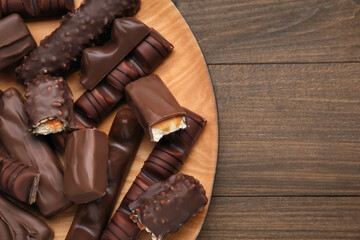 Tasty chocolate bars on wooden table, top view. Space for text