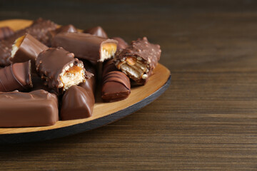 Tasty chocolate bars on wooden table, space for text