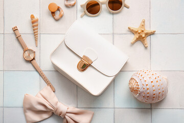 Stylish bag and different accessories on white tile background