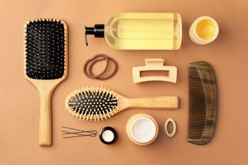 Flat lay composition with wooden hairbrushes and different cosmetic products on light brown...