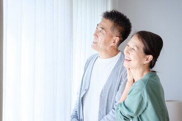 窓の外を眺めるシニア夫婦