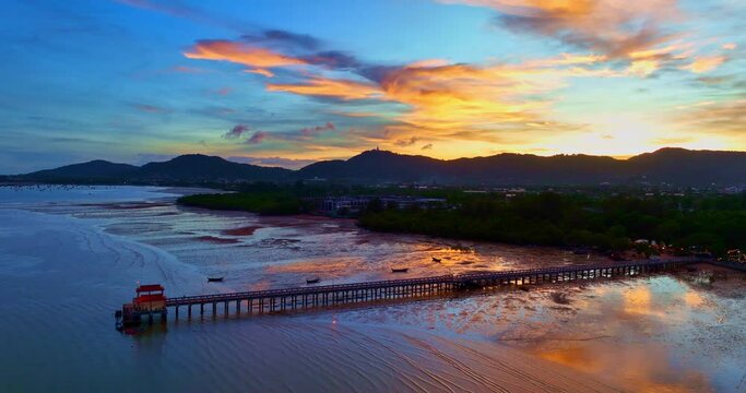 .aerial photography cloud above Palai pier at beautiful sunset..Palai pier is next to Chalong pier..fishing boats parking on the beach..colorful cloud above the mountain range background.