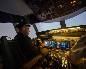 A man is studying to be a pilot in an aircraft simulator. 