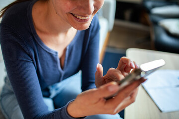 Obraz na płótnie Canvas Young woman using a smart phone at home