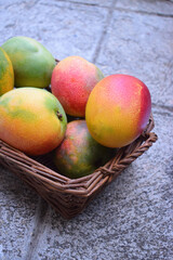 Tropical mango fruits in wooden basket