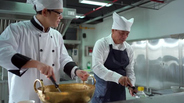 Asian chefs cooking in the restaurant kitchen.