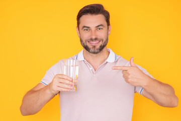 Man drinking fresh water. Male model holds glass of clear water. Healthy lifestyle, health care. Mineral water refreshment, daily dose of clean aqua, dehydration. Portrait of man drinking water.