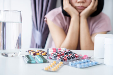 Asian woman bored of Taking Multiple Packs of Medicine Long-term Medication for a Chronic Condition