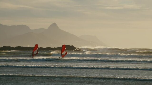 Kitesurfers on the ocean racing with big waves Cape Town
