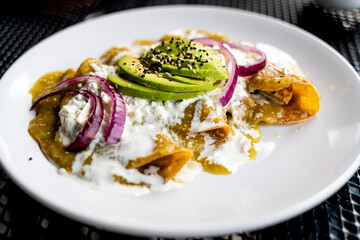 enchiladas verdes with avocado, onion and cheese